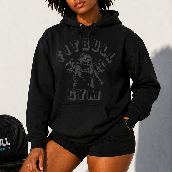 Person wearing a black 'FITBULL GYM' hoodie and shorts on a plain background