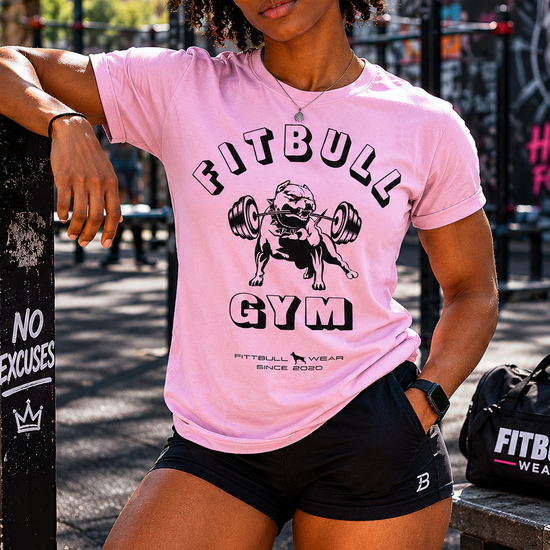 Person wearing a pink 'Fitbull Gym' t-shirt in an outdoor setting.