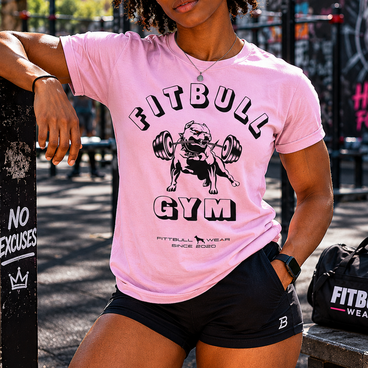 Person wearing a pink 'Fitbull Gym' t-shirt in an outdoor setting.