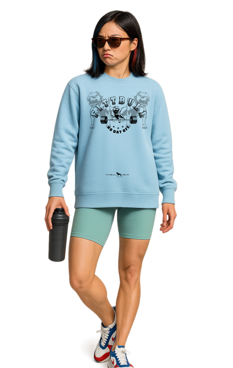 Woman wearing a light blue sweatshirt Fitbull with graphic No Day Off design, green shorts, and colorful sneakers on a white background.