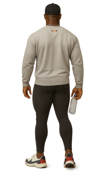 A man wearing a gray, sports Fitbull sweatshirt and black leggings holding a white towel.