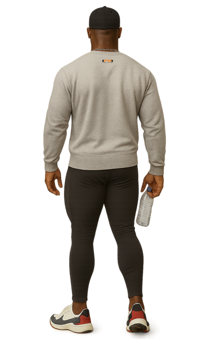 A man wearing a gray, sports Fitbull sweatshirt and black leggings holding a white towel.