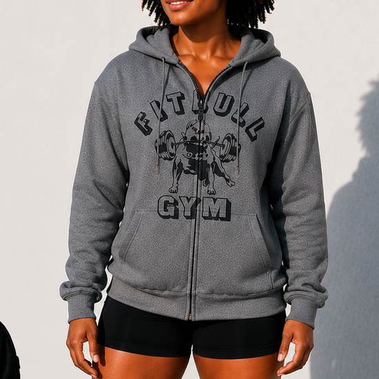 Person wearing a gray 'Fitbull Gym' hoodie with gym equipment in the background