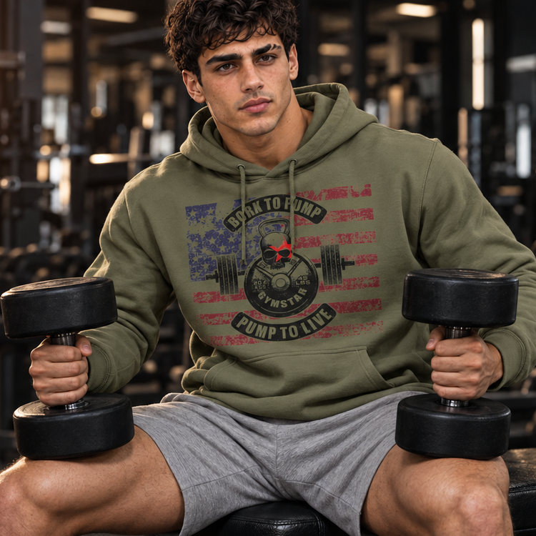 Luca Moretti seated on a gym bench holding dumbbells, wearing a military green GYMSTAR Born to Pump graphic hoodie.