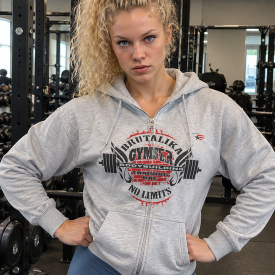 Emelie Johansson wearing a grey GYMSTAR BRUTALIKA zip-up hoodie with a red and black bodybuilding graphic in a gym.