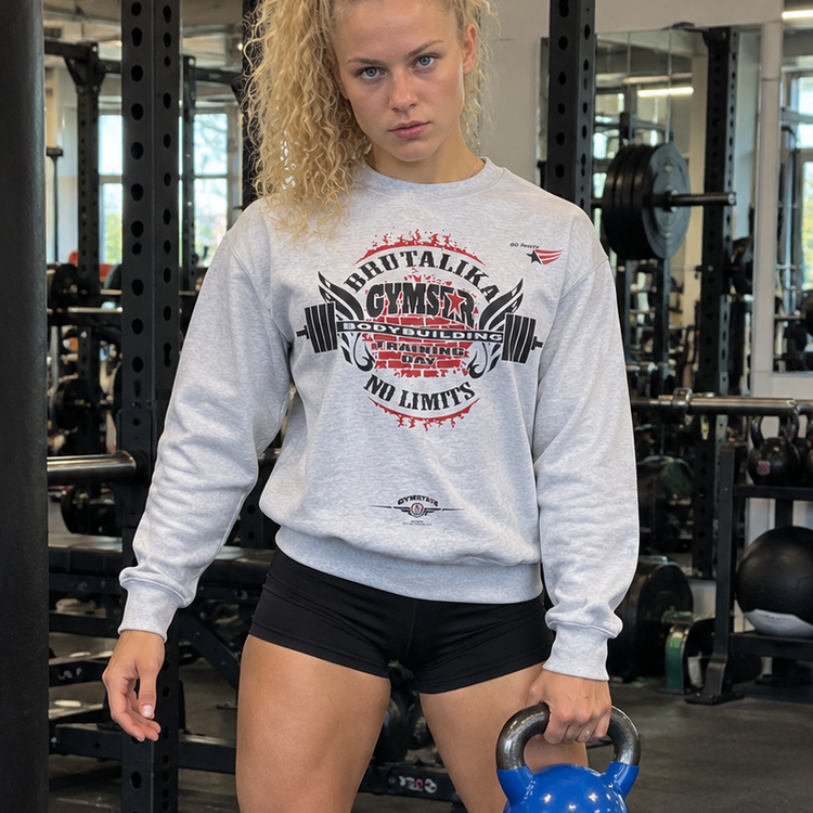 Emelie Johansson wearing a light grey GYMSTAR BRUTALIKA crewneck sweatshirt featuring a red and black weightlifting graphic in a gym.