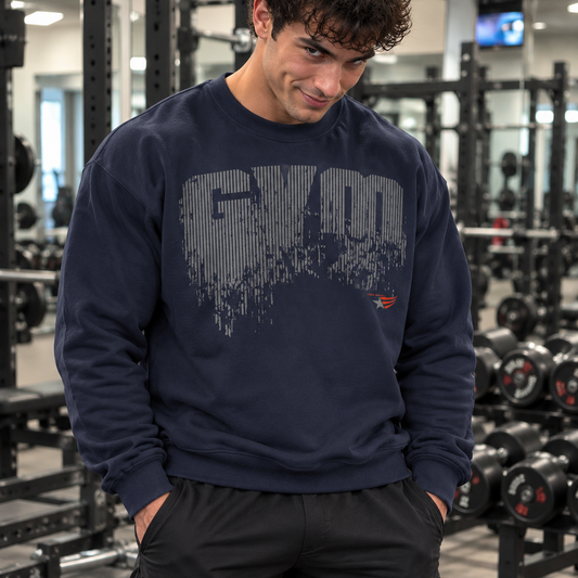 Luca Moretti wearing a navy blue GYMSTAR crewneck sweatshirt with a distressed GYM graphic print, smiling at the camera with his hands in his pockets in a gym.