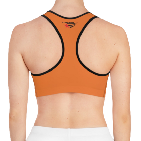 A women's solid orange athletic sports bra Gymstar, shown from the back. It features black trim and a racerback style. The brand's logo is visible on the upper back, just below the neckline.