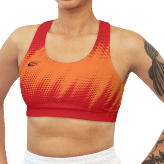 A women's athletic sports bra. It is primarily red with a orange, dotted, gradient pattern that radiates from the sides and bottom. The straps are solid red. A small logo featuring a star and three red and blue stripes is on the left side of the chest.