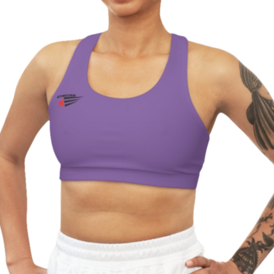 A woman wearing purple athletic sports bra, shown from the front. The straps are solid  and form a racerback style at the back. A small logo featuring a star and three red and blue stripes is on the left side of the chest.