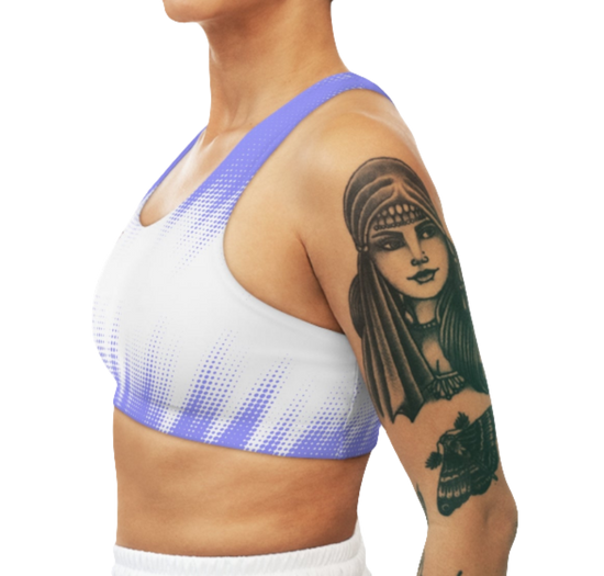 A women's athletic sports bra. It is primarily white with a blue, dotted, gradient pattern that radiates from the sides and bottom. The straps are solid blue. Left side view.