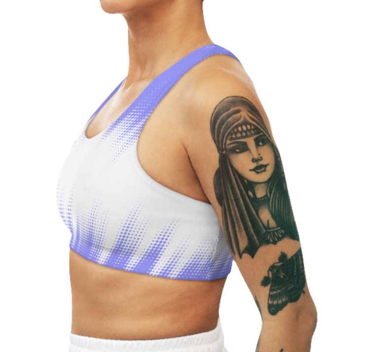 A women's athletic sports bra. It is primarily white with a blue, dotted, gradient pattern that radiates from the sides and bottom. The straps are solid blue. Left side view.