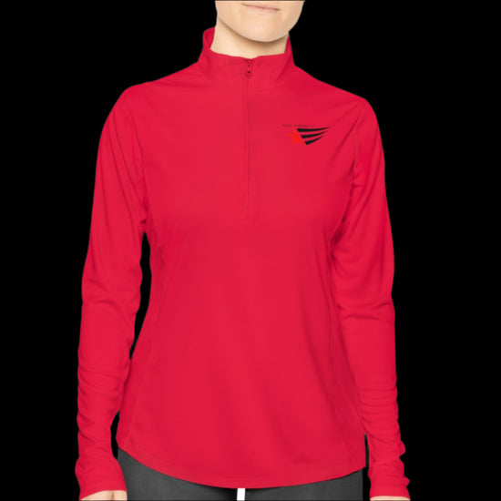 A person wearing a orange half-zip sweatshirt with  logo printed on the front.