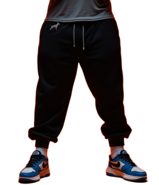 Ein Man trägt graue Fitbull-Jogginghosen mit dem Logo der Marke. 
