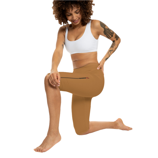 A woman wearing pair of brown Gymstar fitness leggings with a small logo on the left thigh area, designed for women. Front action  view.