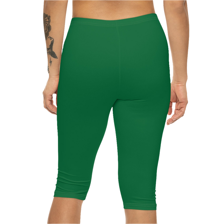 A woman wearing green high-waisted fitness leggings Gymstar with a logo on the waistband, paired with white sneakers. Rear  view.