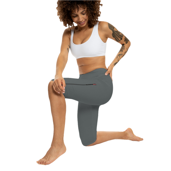 A woman wearing pair of gray Gymstar brand fitness leggings featuring a mid-rise waist and a logo, designed for yoga and other workouts. Front action view.