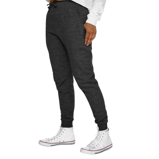 A person standing sideways, wearing gray joggers and white sneakers. The joggers have a ribbed bottom and waistband cuffs, and feature two side pockets and a back pocket.