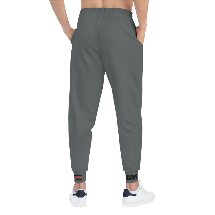 A person standing back side, wearing silver gray joggers Gymstar with a logoand white sneakers. The joggers have a ribbed bottom and waistband cuffs, and feature two side pockets.