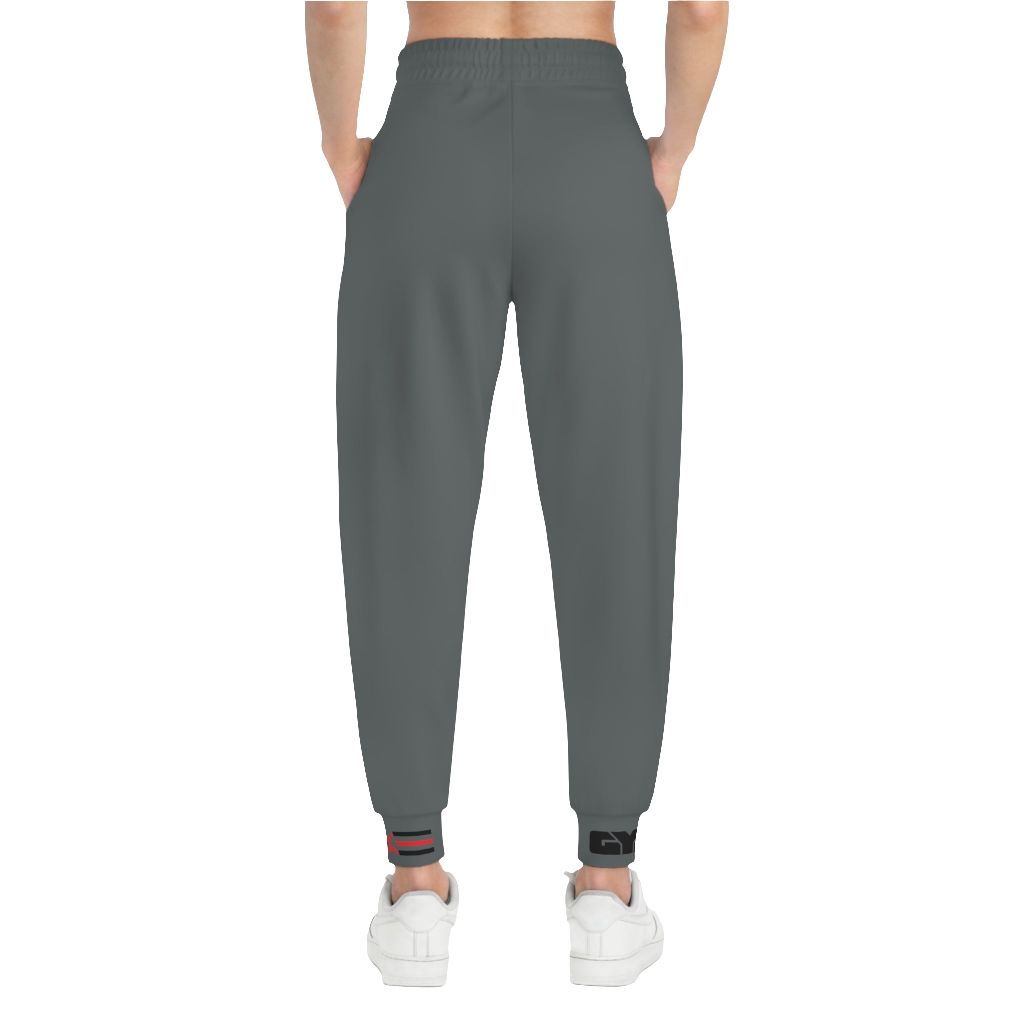 A person standing frontal, wearing silver gray joggers Gymstar with a logoand white sneakers. The joggers have a ribbed bottom and waistband cuffs, and feature two side pockets.