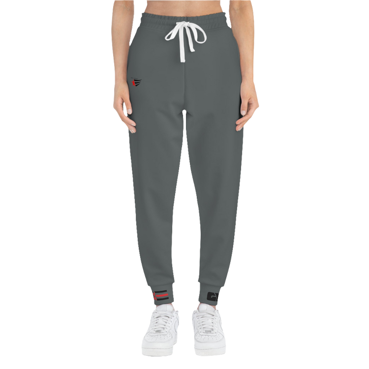 A person standing frontal, wearing silver gray joggers Gymstar with a logoand white sneakers. The joggers have a ribbed bottom and waistband cuffs, and feature two side pockets.