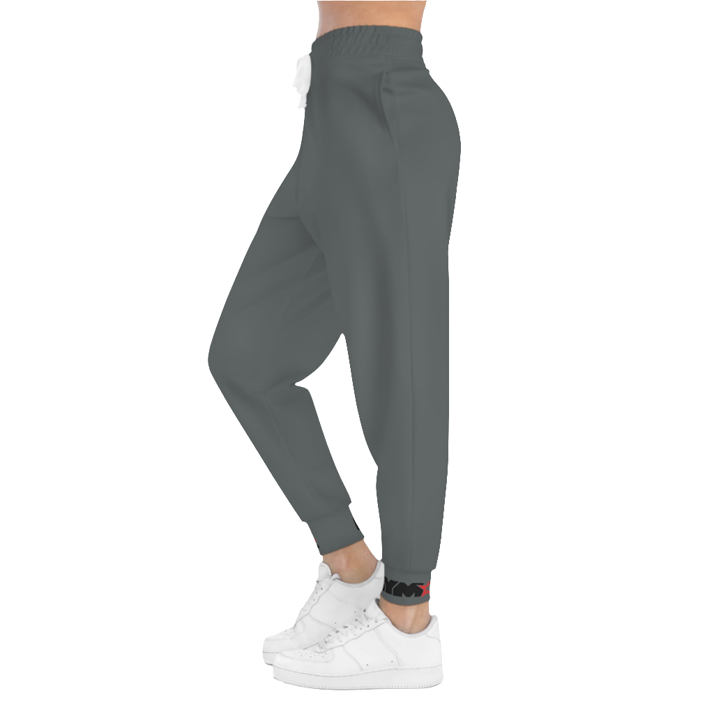 A person standing frontal, wearing silver gray joggers Gymstar with a logoand white sneakers. The joggers have a ribbed bottom and waistband cuffs, and feature two side pockets.