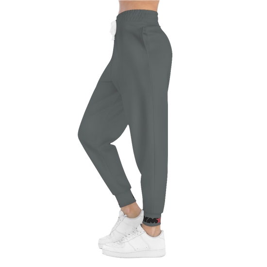 A person standing frontal, wearing silver gray joggers Gymstar with a logoand white sneakers. The joggers have a ribbed bottom and waistband cuffs, and feature two side pockets.