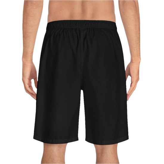 A man wearing black sports shorts with an elastic waistband and drawstrings, featuring a logo on the left leg  back side view.