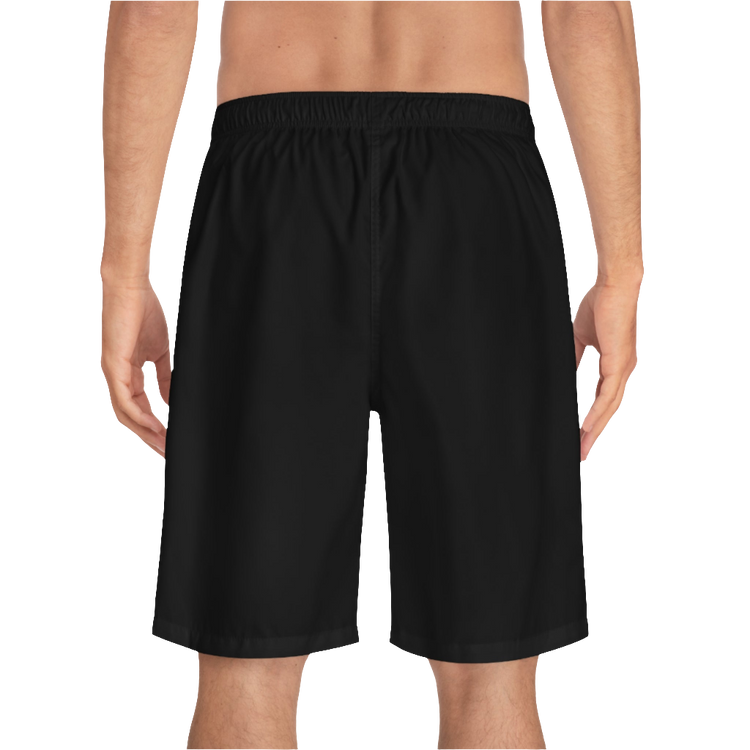 A man wearing black sports shorts with an elastic waistband and drawstrings, featuring a logo on the left leg  back side view.