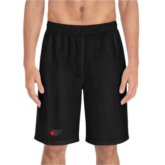 A man wearing black sports shorts with an elastic waistband and drawstrings, featuring a logo on the left leg  front side view.
