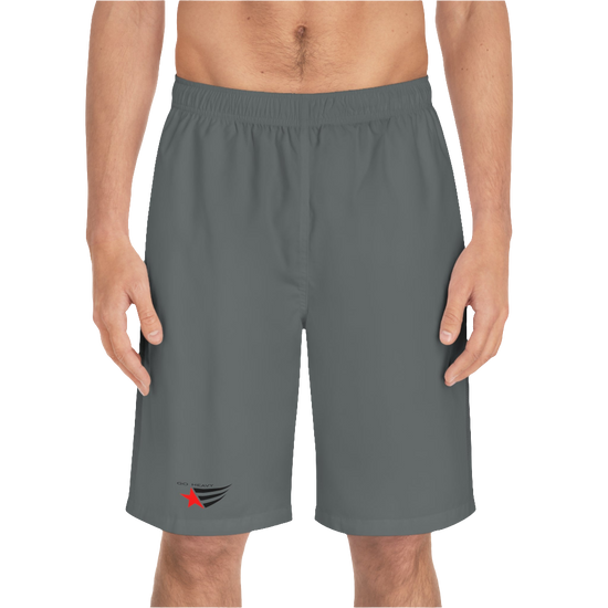 A man wearing grey sports shorts with an elastic waistband and drawstrings, featuring a logo on the left leg  front side view.
