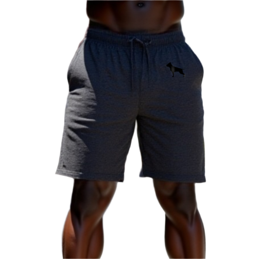 A part of the body of a muscular man shows us blue sports shorts of the sportswear brand Fitbull, with the company's logo.